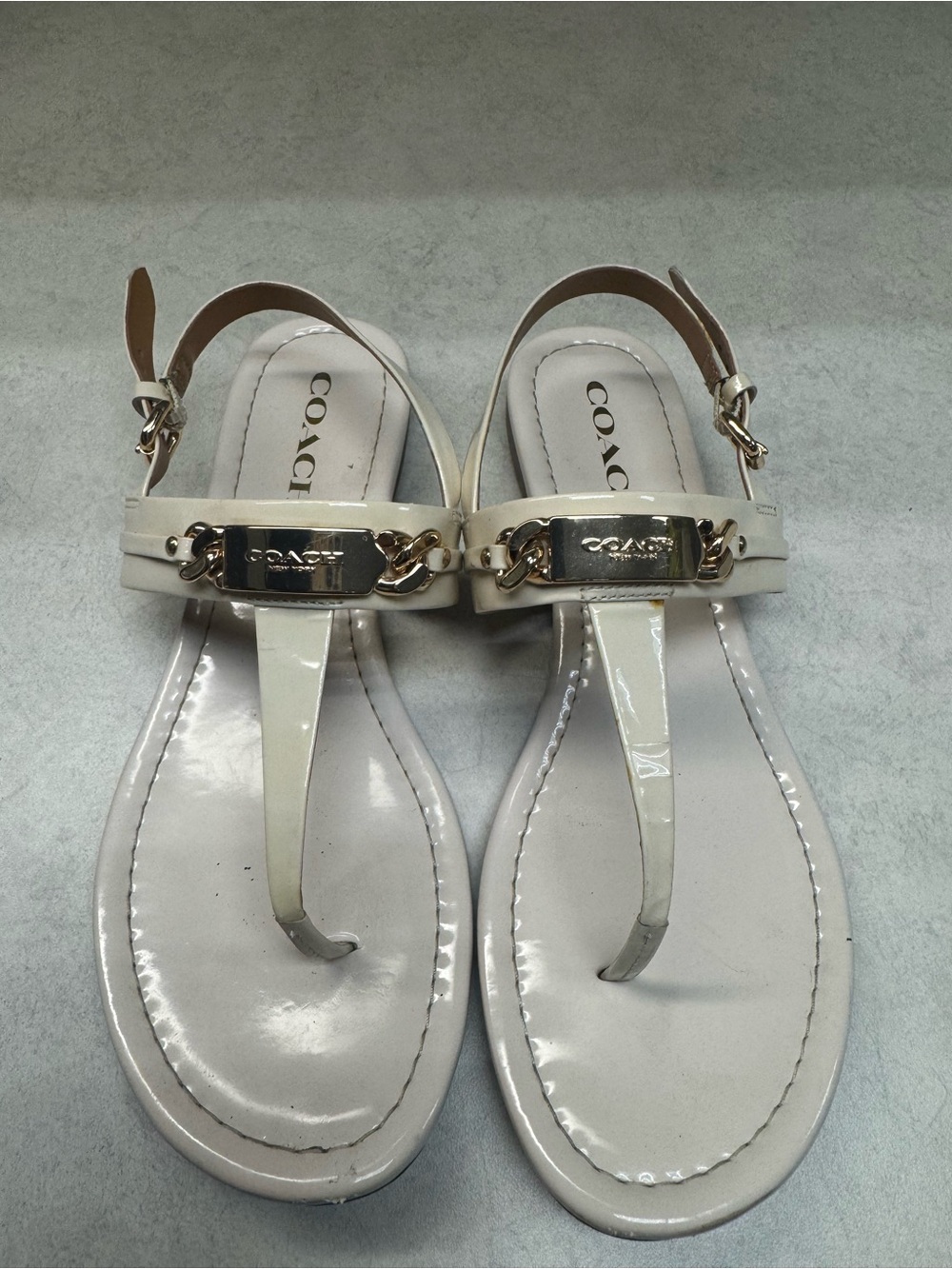 Coach Ivory Patent Leather T‑Strap Sandals with Gold Plaque